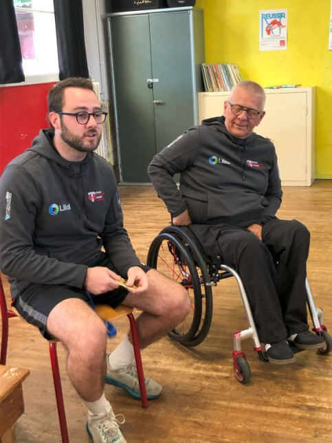 homme en fauteuil roulant et homme assis sur une chaise